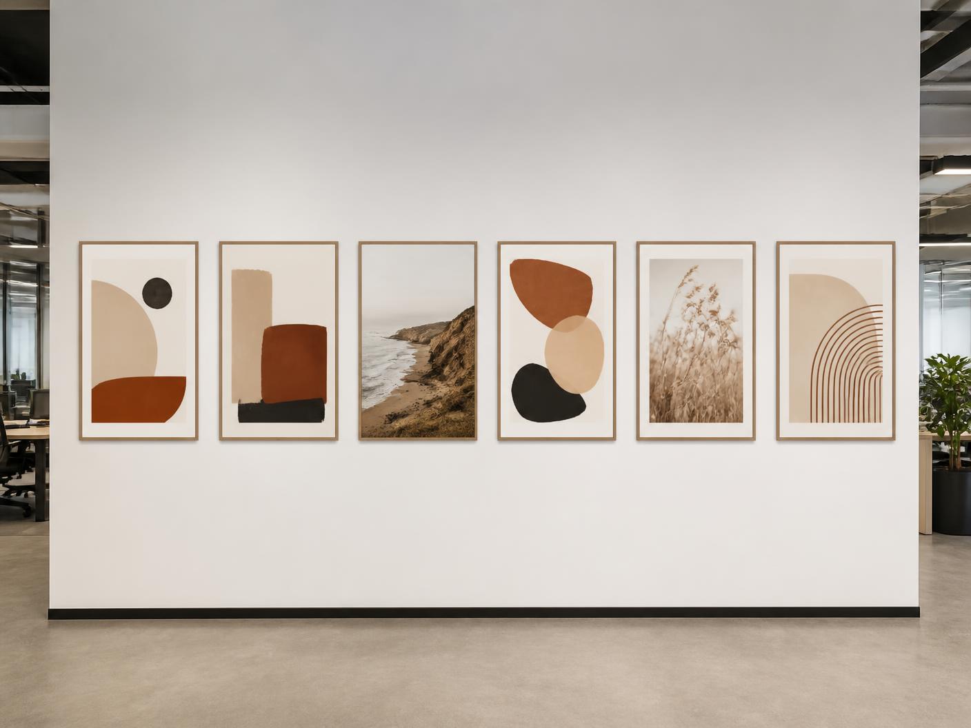 Long row of mounted artworks along an open-plan office corridor